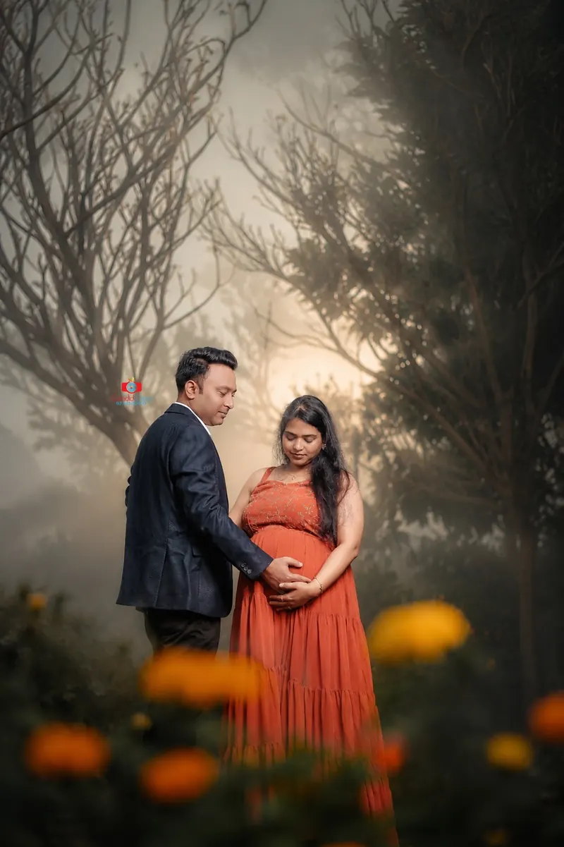 Couple maternity portrait beside a scenic outdoor setting by Candid Clicks